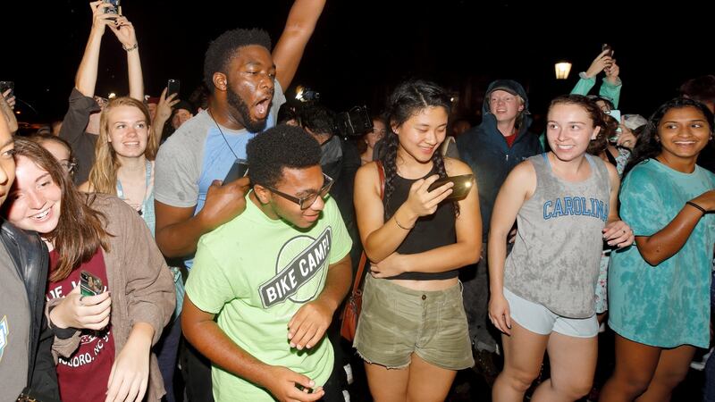 Students and other protesters chant in celebration in front of the toppled statue of a Confederate soldier nicknamed Silent Sam. Jonathan Drake/Reuters.