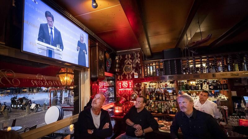 Employees of cafe Marcella in Amsterdam watch a broadcast of a press conference of the Dutch prime minister and health minister on Tuesday on new measures taken to tackle the spread of the Covid-19 pandemic. Photograph: Remko de Waal/ ANP/ AFP/Getty