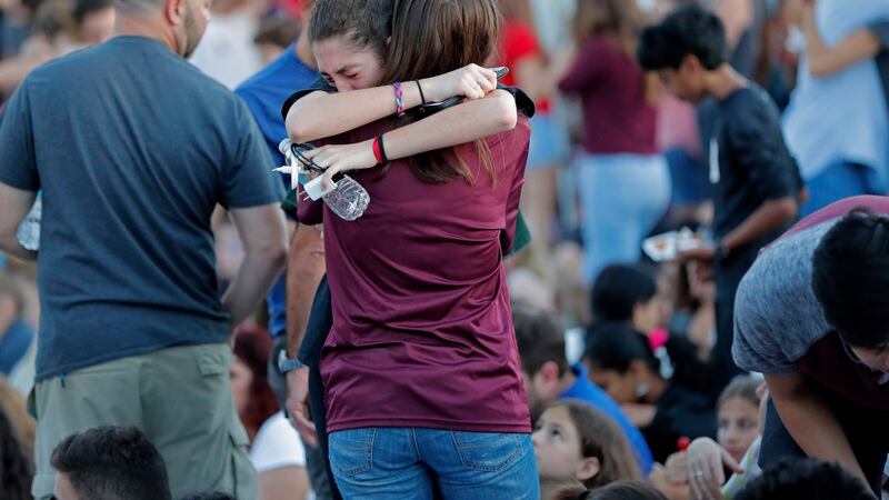People hug one another before the start of a candlelight vigil for the victims of the shooting. Photograph: Gerald Herbert/AP