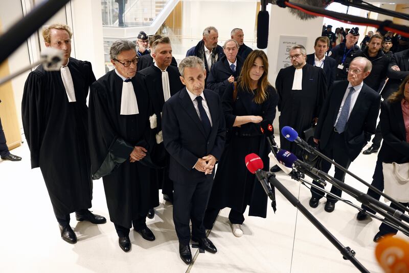 Nicolas Sarkozy and Carla Bruni-Sarkozy speak to the media at the courthouse in Paris. Photograph: Yoan Valat/EPA
