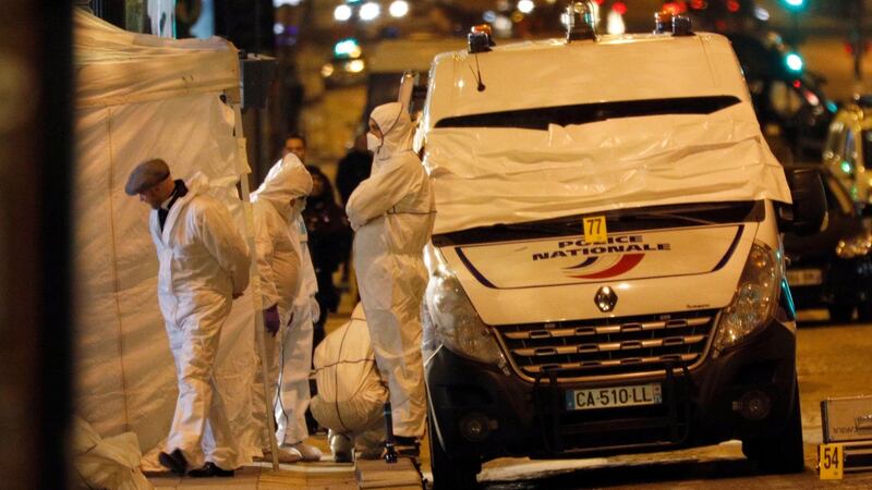 Forensic experts investigate the crime scene after a fatal shooting in which a police officer was killed along with an attacker on the Champs Elysees avenue in Paris, France. Photograph: AP Photo/Kamil Zihnioglu