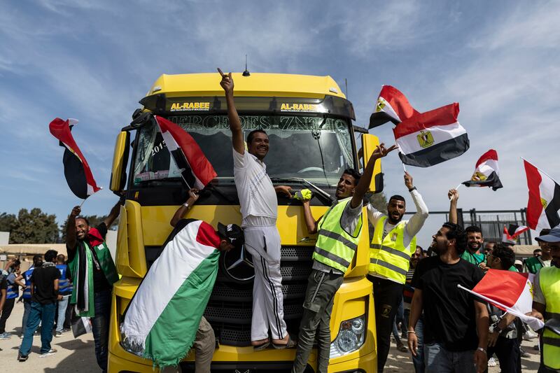 Volunteers and NGO staff celebrate after unloading aid supplies and returning to the Egyptian side of the border in North Sinai on Saturday. Photograph: Mahmoud Khaled/Getty Images