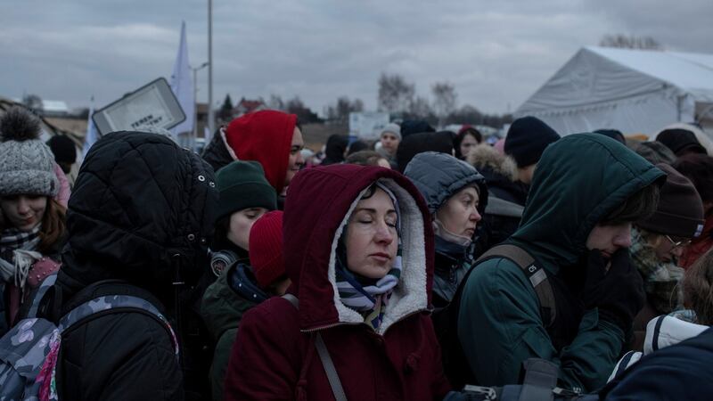Ukrainian refugees  wait to board a bus after crossing the border, in Medyka, Poland. Photograph:  Emile Ducke/The New York Times