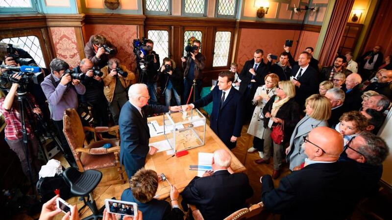 Emmanuel Macron casts his ballot next to his wife, Brigitte Trogneux. Photograph: Eric Feferberg/AFP/Getty Images