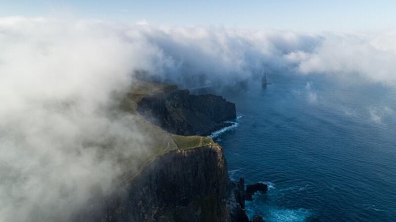 7.44am, July 4th: Low clouds roll off the cliffs and over a tent pitched extremely close to the cliff’s edge.