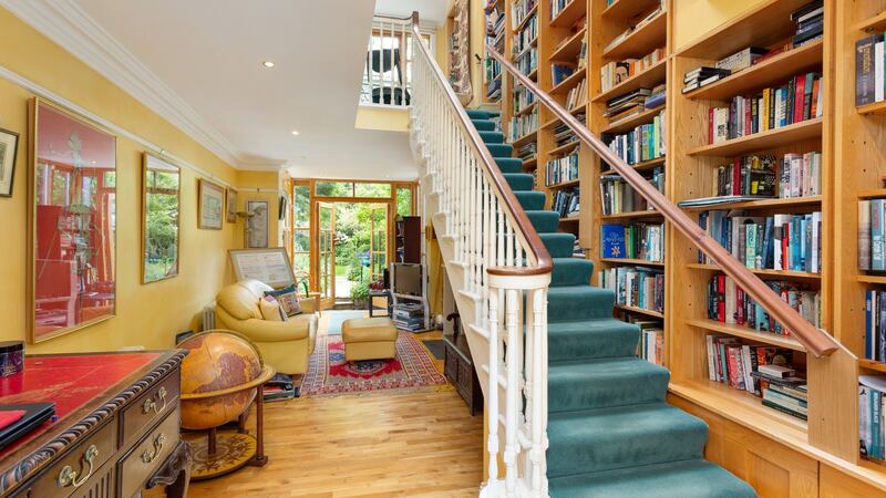 Library-study with a two-storey wall of bookshelves.