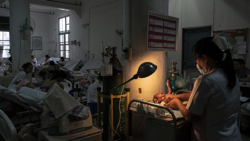 A nurse handles a baby in Fabella Hospital in Manila on October 21st, 2018.  Photograph: Kimberly dela Cruz
