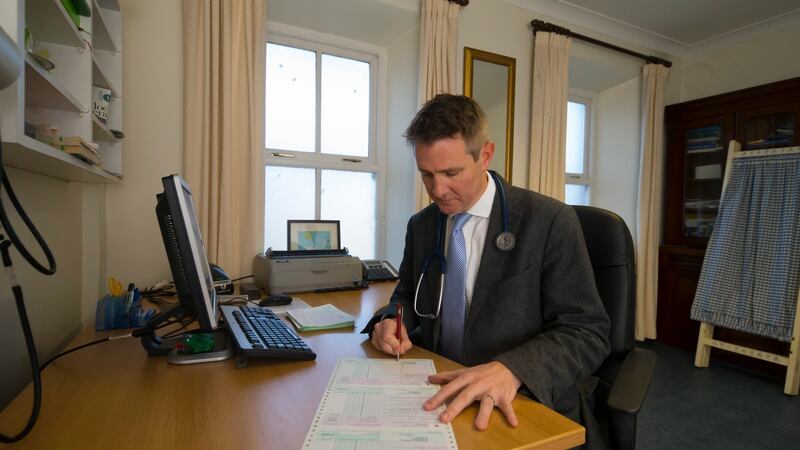 Dr Darach Brennan filling out prescriptions. Photograph:  Patrick Browne