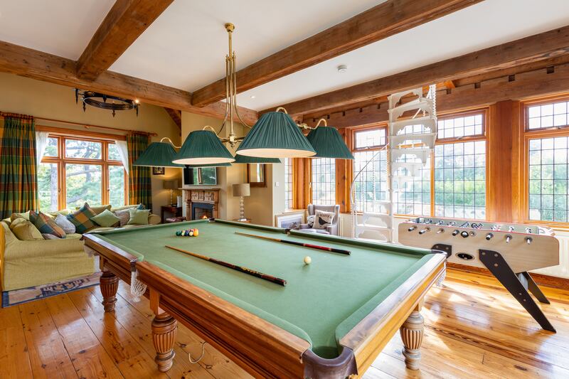 A triple-aspect sittingroom has squashy sofas in an L around a fireplace, as well as a full-size snooker table