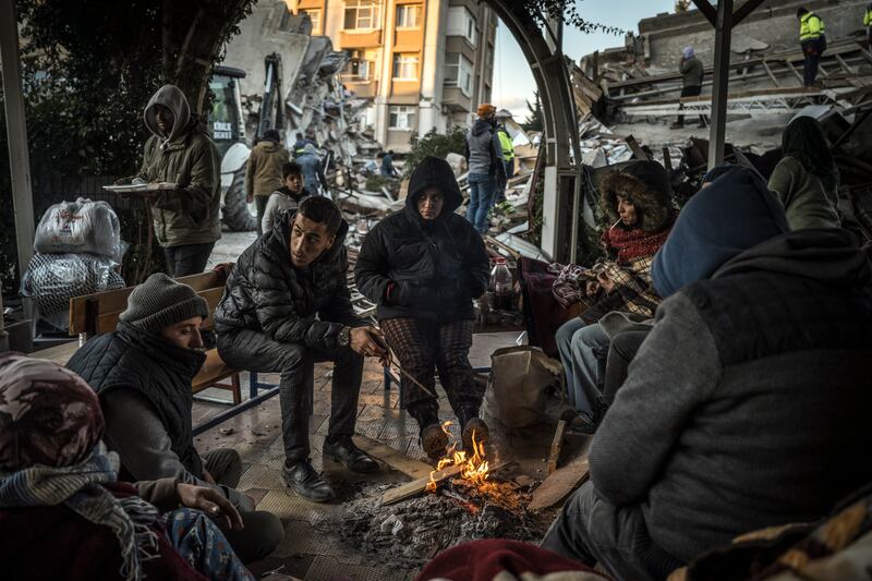 Earthquake survivors gather around a bonfire in Hatay, Turkey. Photograph: Sergey Ponomarev/New York Times