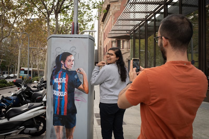A fan is photographed next to the mural of Aitana Bonmatí on Barcelona's Diagonal Avenue on Tuesday. Photograph: David Zorrakino/Europa Press via Getty Images