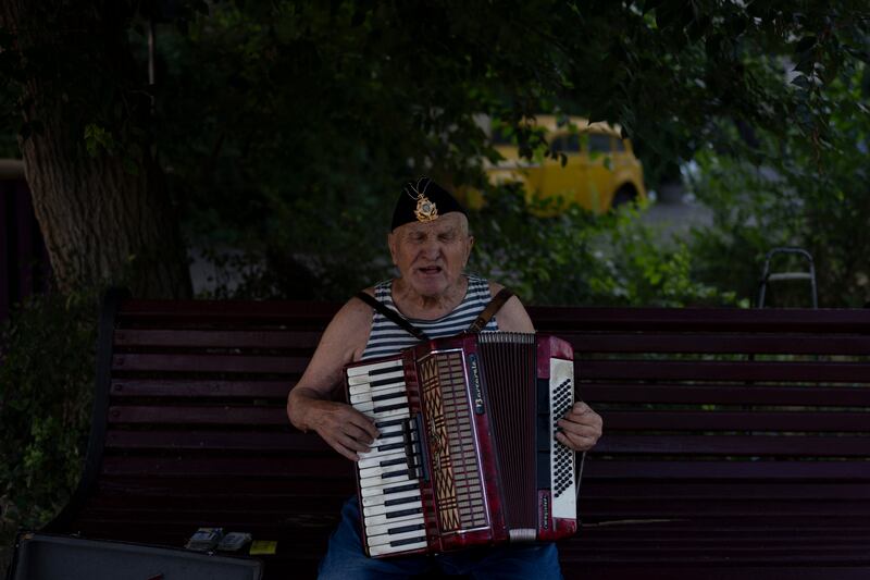 A street performer sings while playing the accordion at a popular beachside attraction in Odesa (Jae C. Hong/AP)