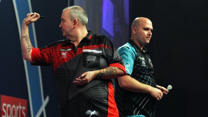 Phil ‘Power’ Taylor (left) of England in action against Rob Cross of England during their PDC World darts final match at the Alexander Palace in north London. Photograph:  EPA/SEAN DEMPSEY