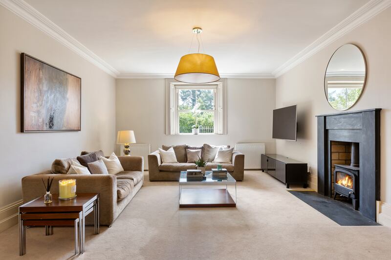 The livingroom is less formal, with sash windows and a solid fuel stove