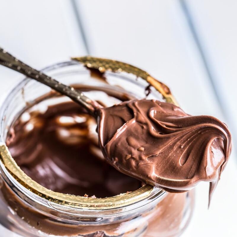 Chocolate spread in spoon. A jar of hazelnut chocolate spread.Chocolate spread in spoon. A jar of hazelnut chocolate spread.