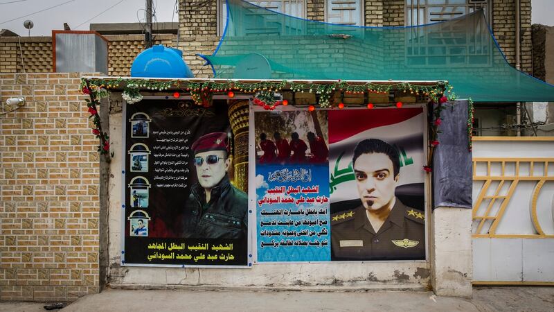 Posters outside the Sudani family home in Baghdad feature larger-than-life photos of Captain Sudani and poems of mourning written by his father. Photograph: Ivor Prickett/The New York Times