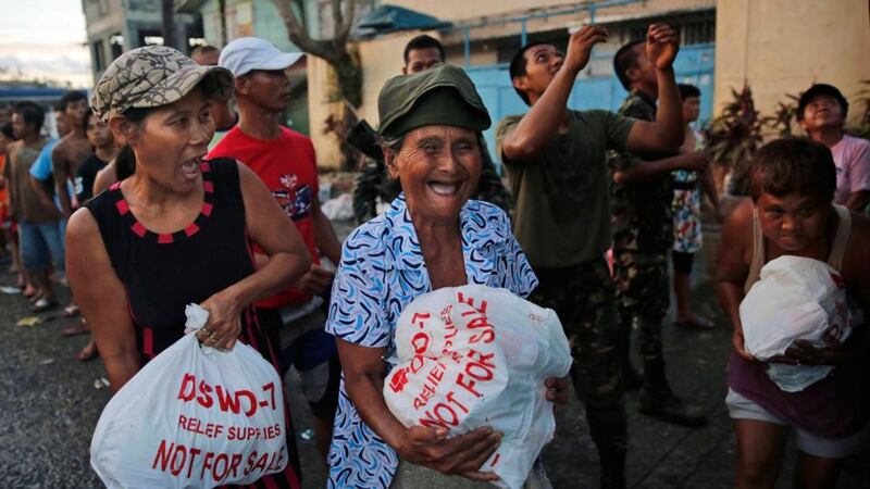 Residents of Tacloban receive food aid from the Philippines army. Photograph: Kevin Frayer/Getty Images