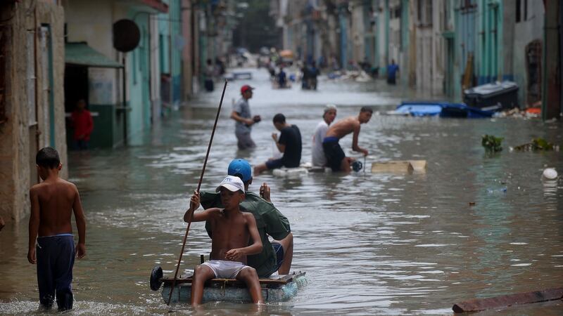 Cubans wade through a flooded street in Havana. Photograph: Yamil Lage/AFP/Getty Images