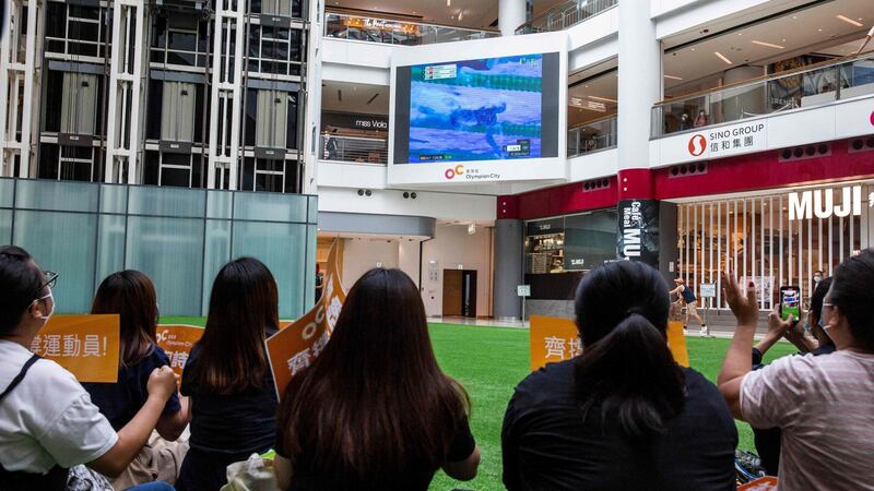 People in a shopping mall in Hong Kong cheer on Siobhan Haughey as she swims to silver in Tokyo. Photograph: Isaac Lawrence/Getty/AFP