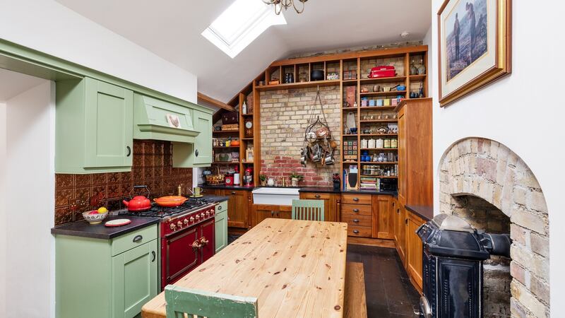 The sage-green and walnut kitchen