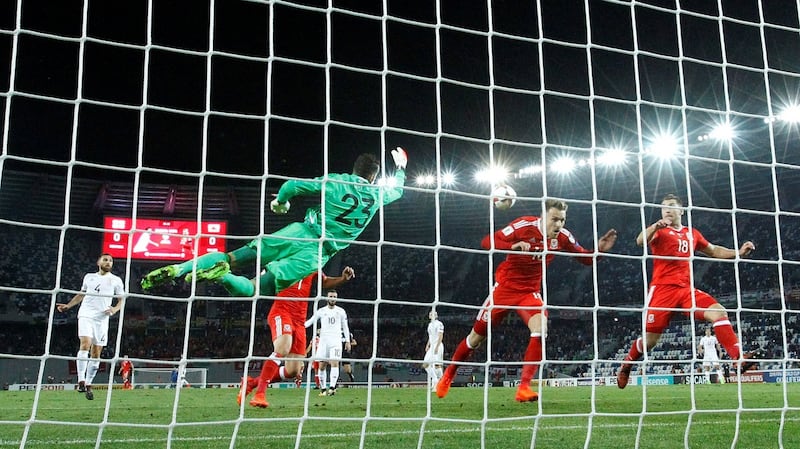 Georgia’s Giorgi Loria punches clear of Wales’ Aaron Ramsey and Sam Vokes. Photograph: David Mdzinarishvili/Reuters