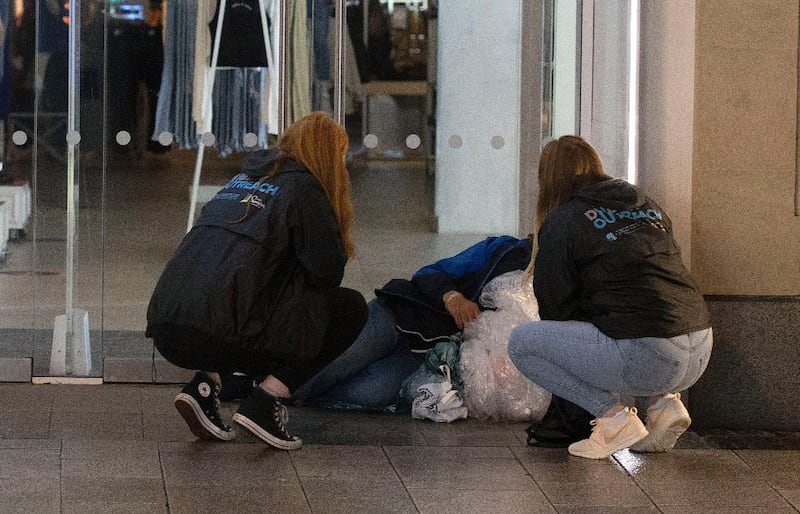 Roisin Casey (L) and Daire Moriarty, both members of the Dublin Simon rough sleeper outreach team speak to a homeless man on Dublin's Henry Street. Photograph: Damien Eagers