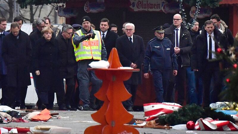 German chancellor Angela Merkel with foreign minister Frank-Walter Steinmeier, interior minister Thomas de Maiziere and Berlin mayor Michael Mueller  visit the terror attack scene at the Christmas market near the Kaiser Wilhelm memorial church in central Berlin. Photograph:  John MacDougall/AFP/Getty