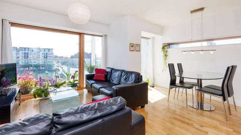 The open-plan livingroom-cum-diningroom and kitchen area has floor-to-ceiling windows