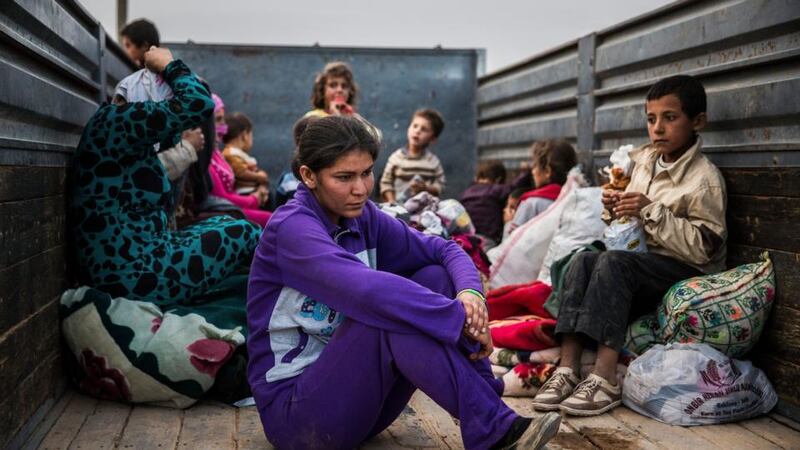 Syrian Kurdish refugees wait to be taken to a shelter after being allowed to cross the border in Yumurtalik, Turkey, just west of Kobani, Syria, yesterday. Photograph: New York Times