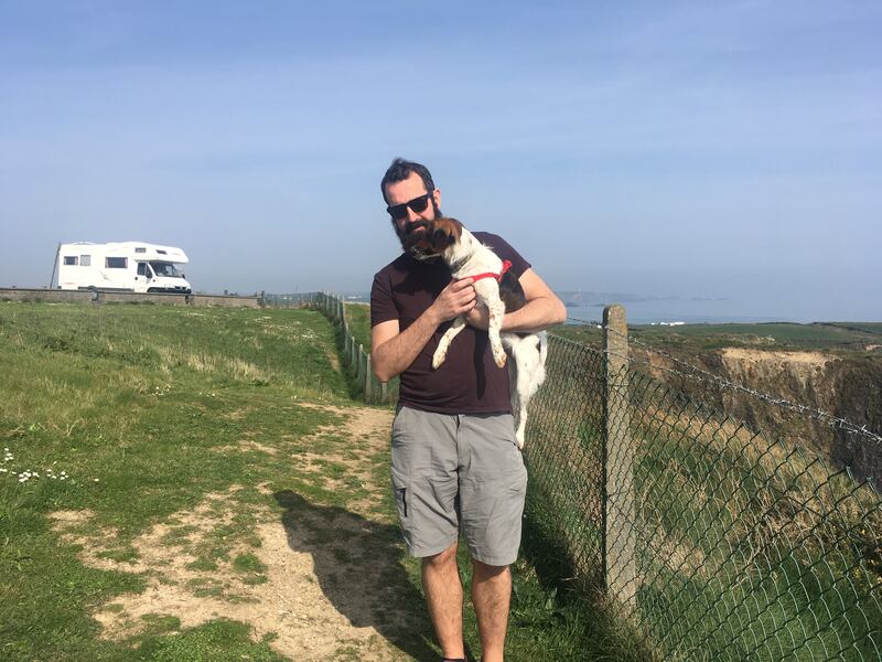 Catherine Conroy's husband Paul McEvoy and their dog Bobby with their campervan in the background.