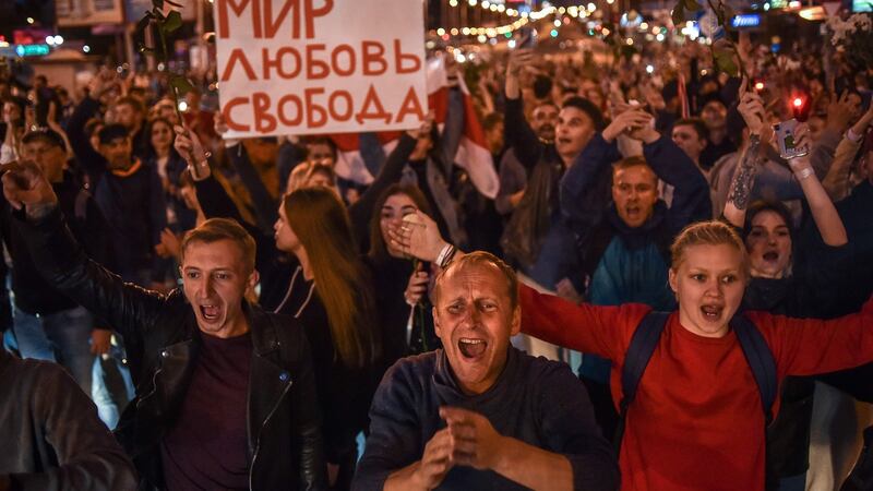 People shout as they hold a poster reading “Peace, Love, Freedom”  in Minsk on Thursday. Photograph:  Sergei Gapon/AFP via Getty Images