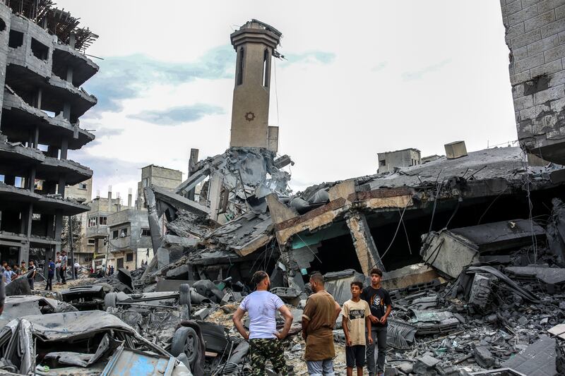 People inspecting the destruction of their homes in Gaza City. Photograph: Samar Abu Elouf/The New York Times
                      