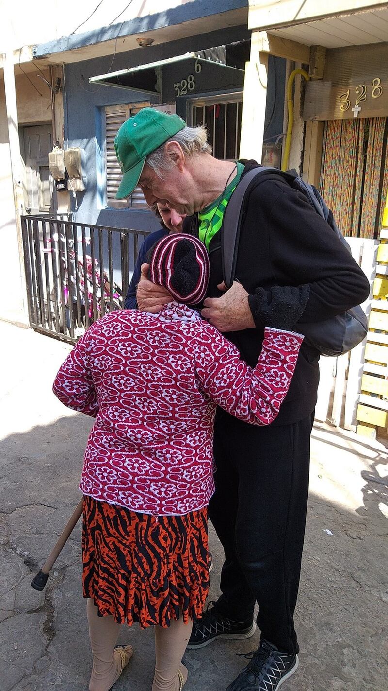 Fr Pat Clarke is greeted in the street by one of his devoted parishioners.