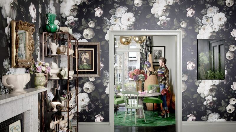 The walls are covered in a huge floral print wallpaper by Ellie Cashman