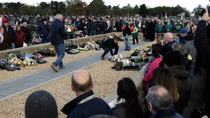 Republicans lay wreaths at Thomas Begley’s grave during a controversial commemoration at Milltown Cemetery in west Belfast for the Shankill Road bomber. Photograph: Peter Morrison/PA