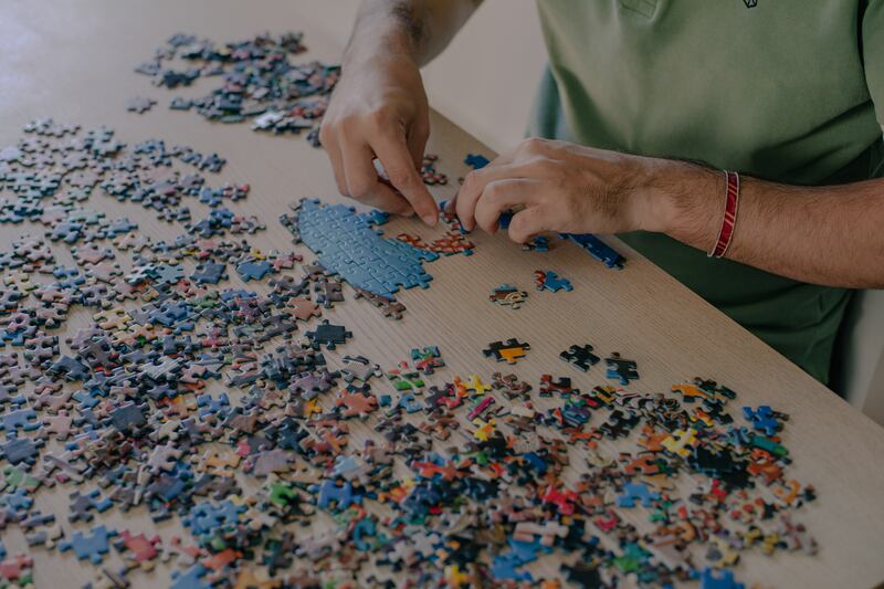 Alejandro Clemente León solving a jigsaw puzzle. Photograph: Hannah Cauhepe/The New York Times