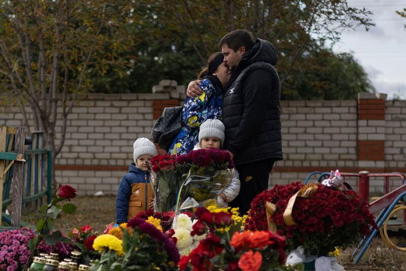 People pay tribute near the memorial for the victims of a Russian rocket attack in the village of Hroza. Photograph: Alex Babenko/AP
