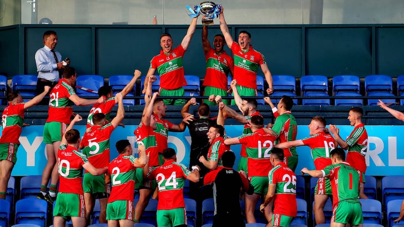 Paddy Small, James McCarthy and John Small lift the trophy as Ballymun Kickhams celebrate  victory over Ballyboden St Enda’s in the Dublin SFC final at Parnell Park.  Photograph: Ryan Byrne/Inpho