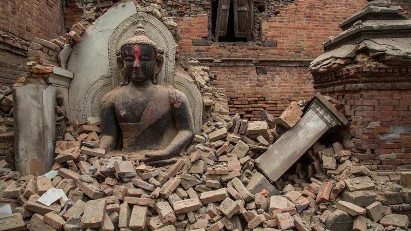 A Buddha statue is surrounded by debris from a collapsed temple in the UNESCO world heritage site of Bhaktapur in Nepal. Photograph:  Omar Havana/Getty Images.