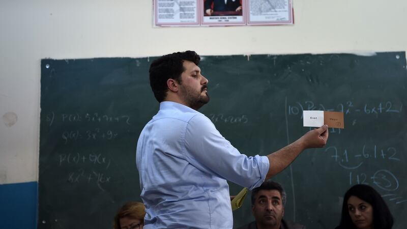 An electoral staff member shows a ballot paper in an Istanbul polling station. Photograph: AFP/ Ozan Koseozan Kose
