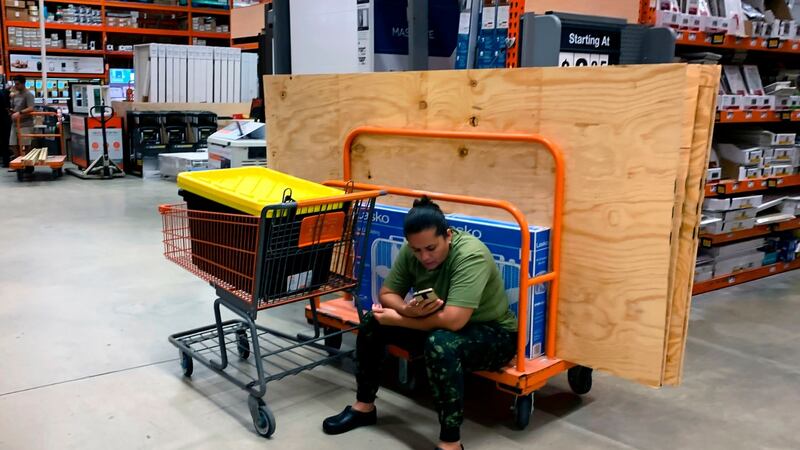 A woman watches her phone while stock up with hurricane supplies at Home Depot in Miami on Thursday. Photograph: Getty Images