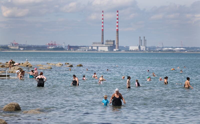 Marcella Inglesmith and her grandson Oakley Inglesmith (5) from Co Wicklow in the sea with large crowds enjoying the sunshine at Seapoint Strand near Monkstown, Co Dublin, in July.  Photograph: Bryan O’Brien 
