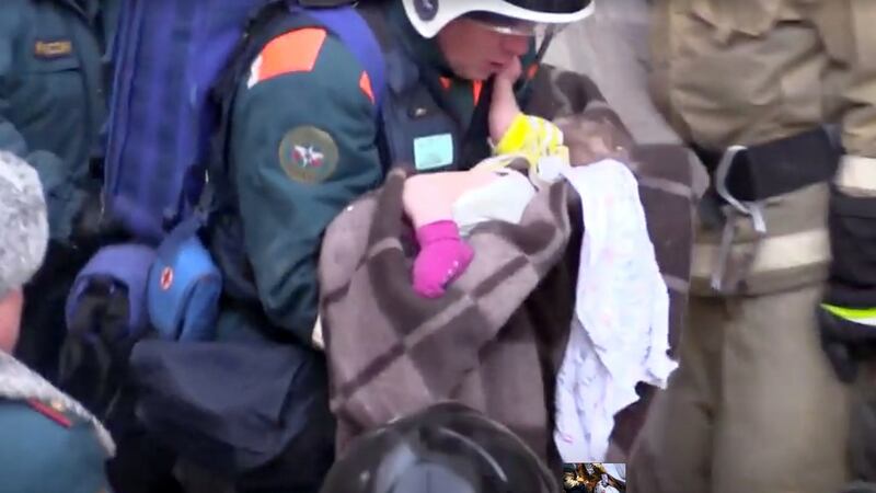 A rescuer carries a 10-month-old child found in the rubble of a Russian apartment block. Photograph: via Reuters TV