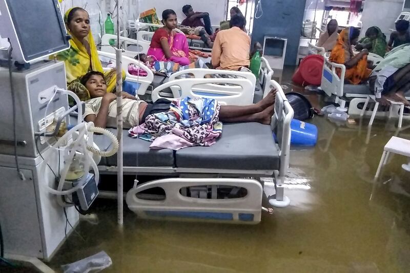 Patients and their relatives rest in beds as they wade through floodwaters during heavy monsoon rain at waterlogged Nalanda Medical College and Hospital in Patna on September 28th. Photograph: Sachin Kumar/AFP/Getty