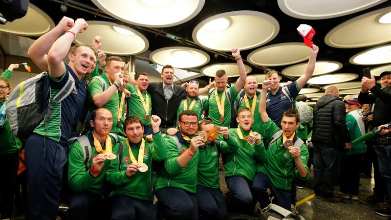 Team Ireland’s medal-winning soccer players pose for a photograph with ex-Republic of Ireland player Niall Quinn after arriving back to Dublin Airport from Abu Dhabi. Photograph: Nick Bradshaw/The Irish Times