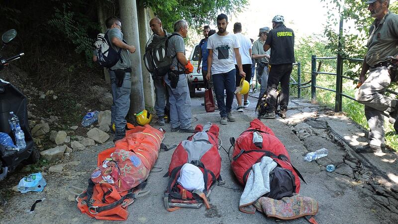 Bodies of victims lie in front of rescuers in the central Italian town of Pescara del Tronto on Wednesday. Photograph: Marco Zeppetella/AFP/Getty Images