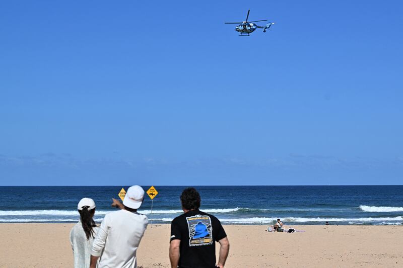 A helicopter scans the water following a shark attack at Long Reef beach on Saturday. Photograph: Saeed Khan/AFP via Getty Images         