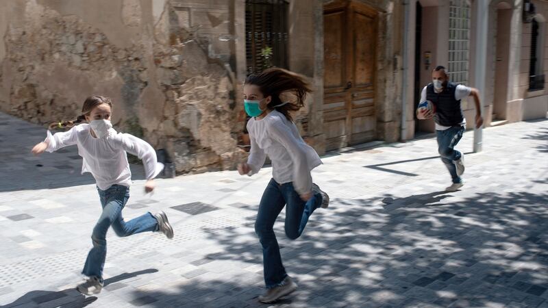 Joan (45), chases his daughters Ines (11) and Mar (9) as they play in the street on Sunday in Barcelona as after six weeks stuck at home, Spain’s children  aer now allowed outside. Photograph: Josep Lago/AFP