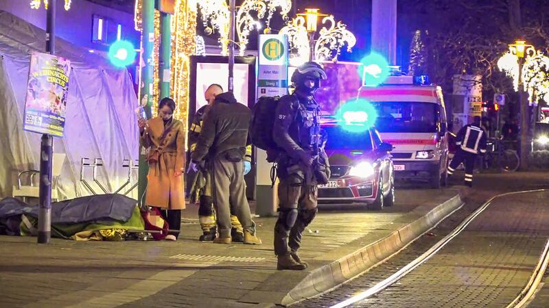 An injured person lies on a stretcher as police and ambulances stand next to the market. Photograph: Erik-Holm Langhof/NEWS5/AFP via Getty