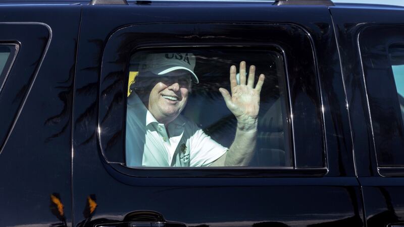 President Donald Trump waves from his motorcade on his way  to his Mar-a-Lago estate in Florida on Thursday. Photograh: Greg Lovett/Palm Beach Post via AP